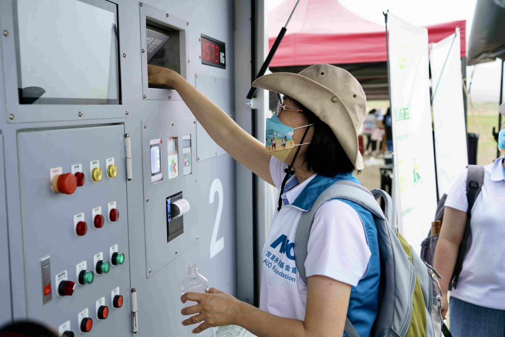 志工們將拾起的寶特瓶投入「好歸塑專車」，讓廢棄塑料空瓶可以直接粉碎、縮小體積，未來將可再製成購物袋、寶特衣、悠遊卡等生活用品